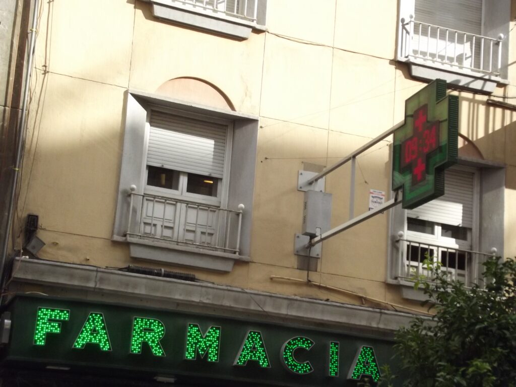 Farmacia - Calle Recogidas, Granada - green cross (Susra: Wikimedia Commons)